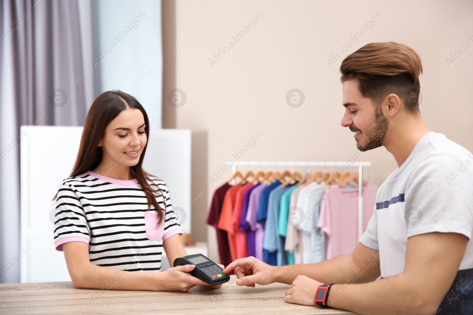 Photo of Man using terminal for contactless payment in shop