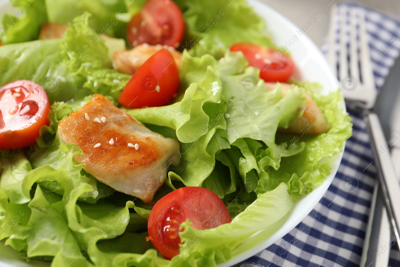 Photo of Delicious salad with chicken and cherry tomato on table, closeup