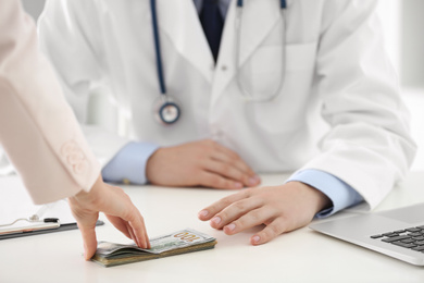 Photo of Patient giving bribe to doctor in clinic, closeup. Corrupted medicine