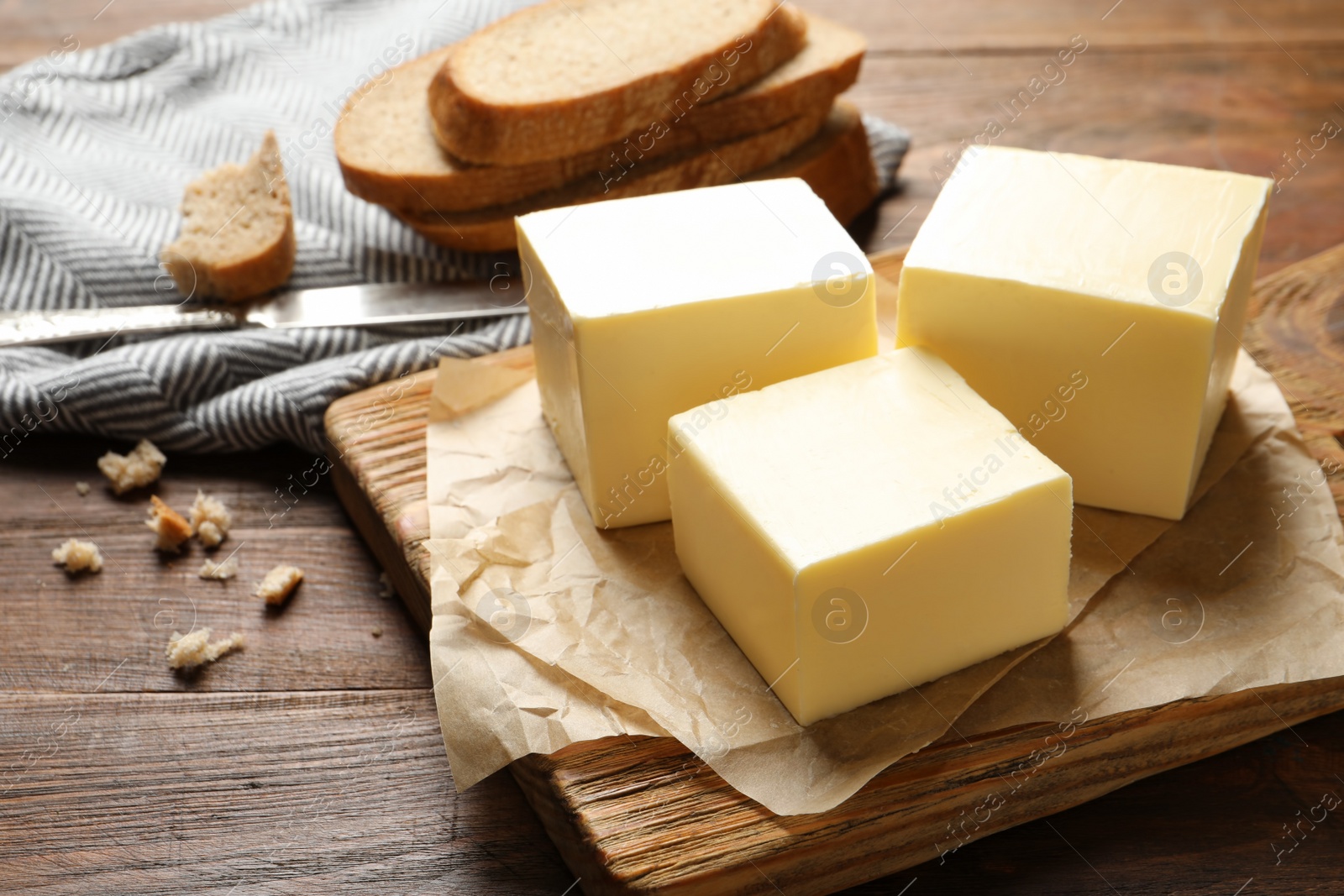 Photo of Wooden board with fresh butter on table. Space for text