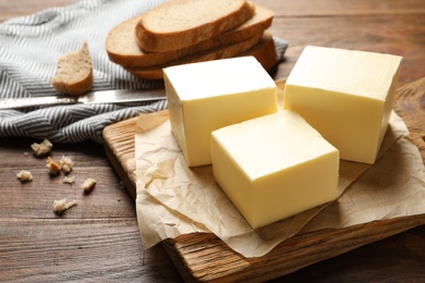 Wooden board with fresh butter on table. Space for text