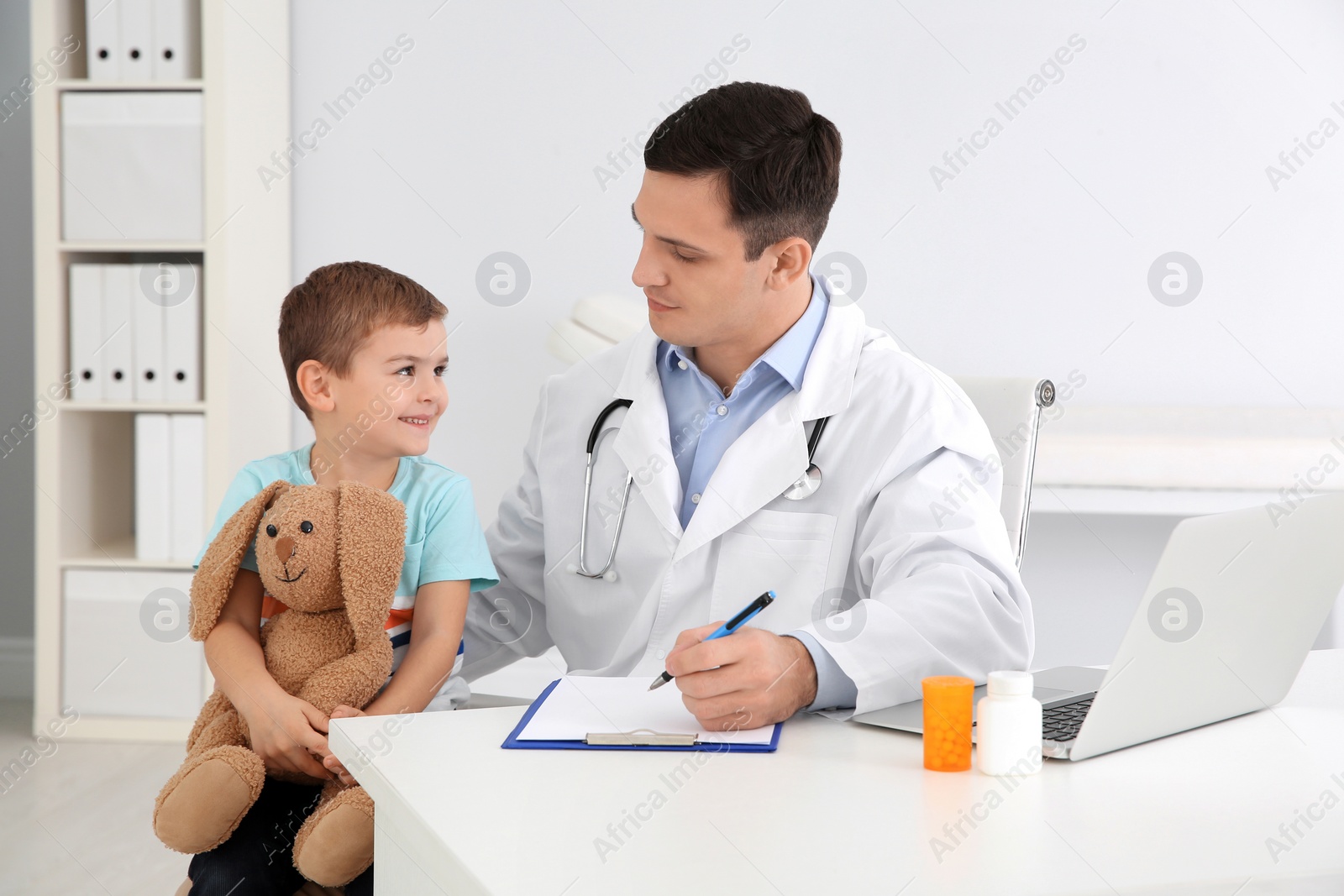 Photo of Children's doctor working with little patient in hospital