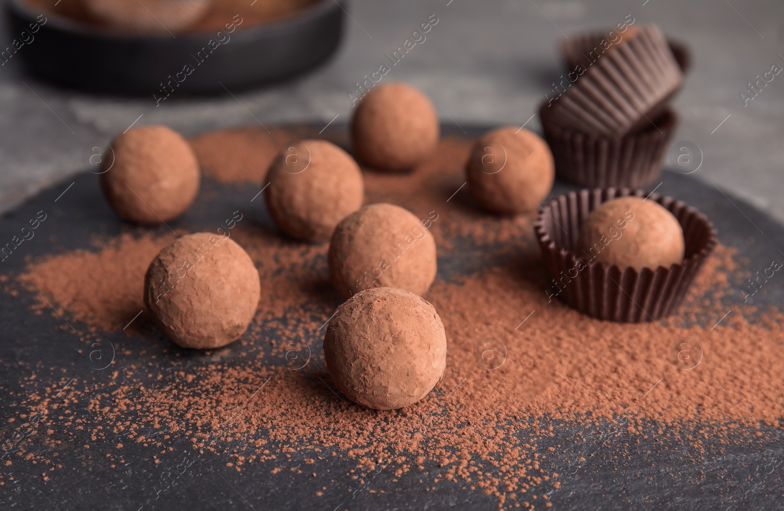 Photo of Chocolate truffles powdered with cocoa on slate plate