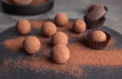 Chocolate truffles powdered with cocoa on slate plate