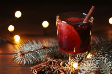 Photo of Mulled wine with cinnamon, anise and orange in glass on table. Space for text