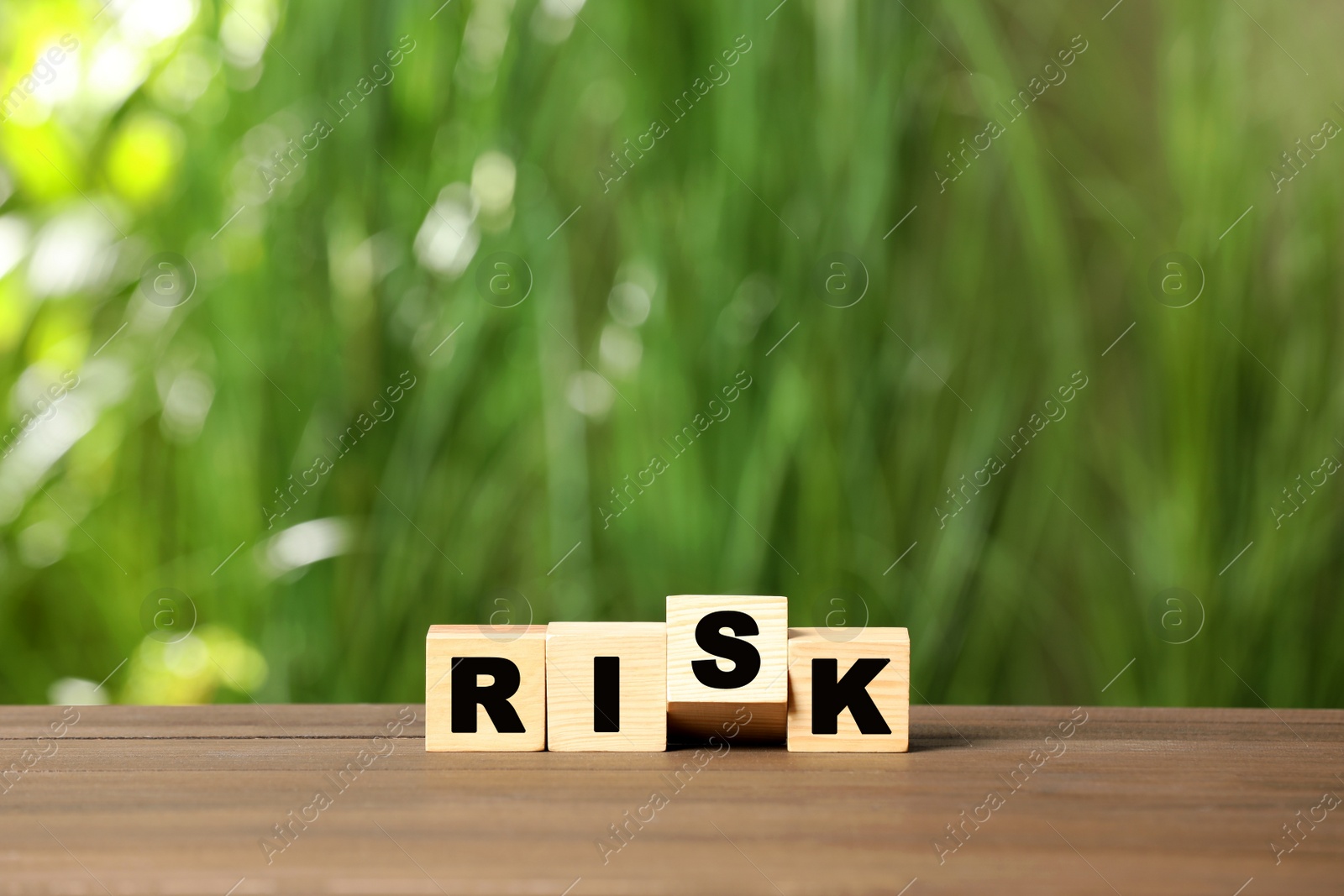 Photo of Cubes with word Risk on wooden table