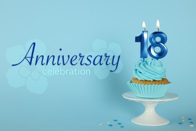 Image of Delicious cupcake with number shaped candles on light blue background. Coming of age party - 18th birthday. Anniversary celebration