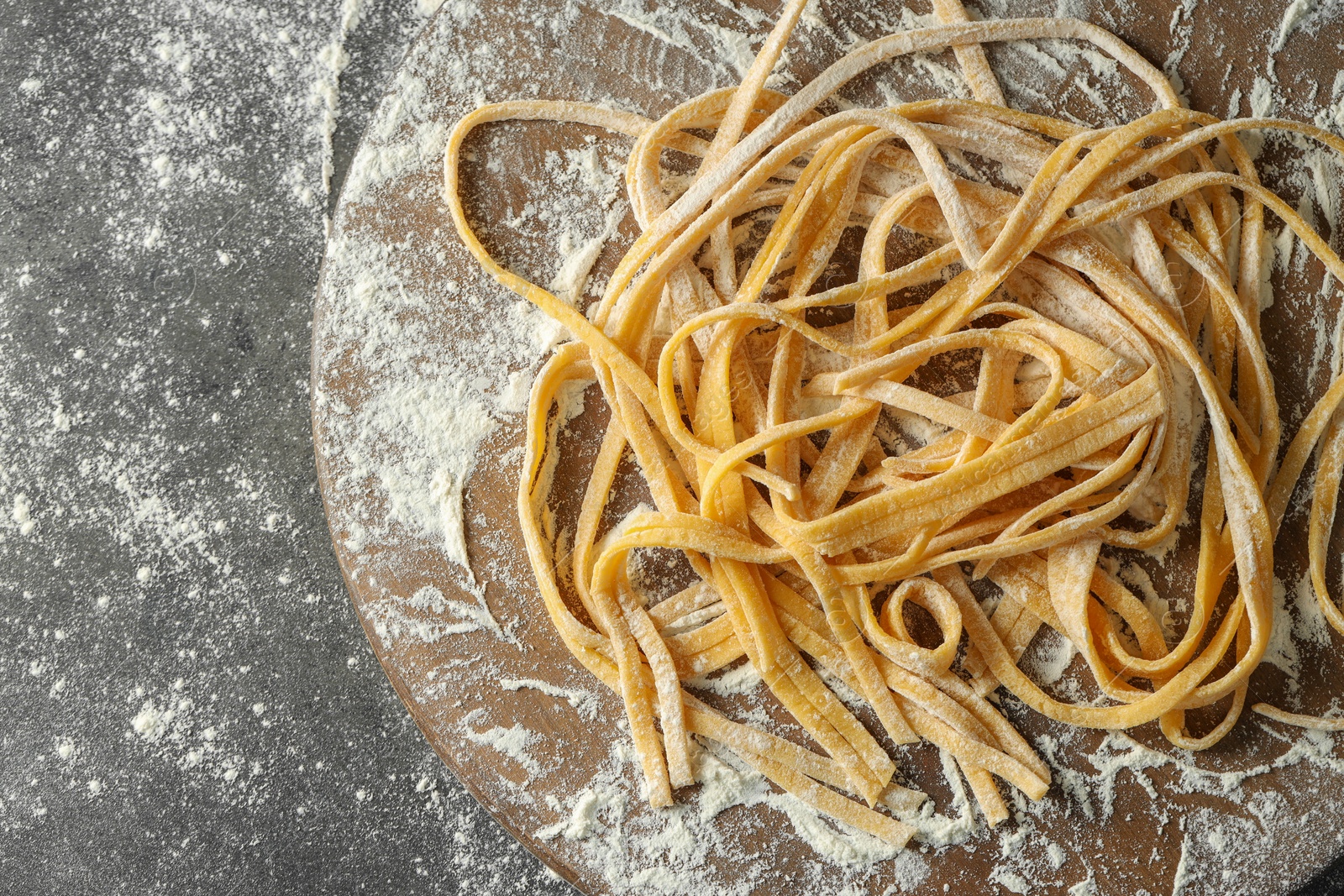 Photo of Uncooked homemade pasta on dark grey table, top view