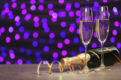 Photo of New year composition with champagne and space for text against blurred Christmas lights