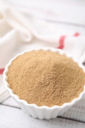 Photo of Dietary fiber. Psyllium husk powder in bowl on wooden table, closeup