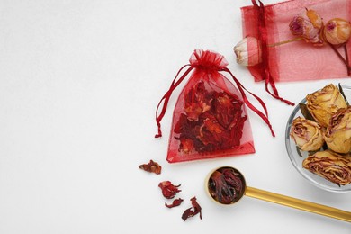 Photo of Scented sachets with dried rose and hibiscus flowers on white table, flat lay. Space for text