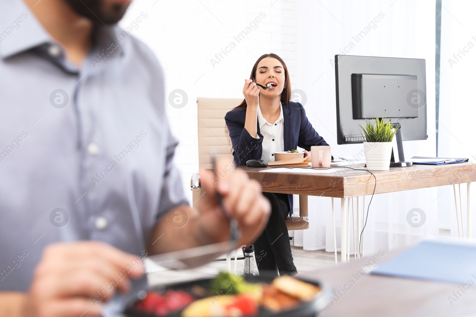 Photo of Office employee having lunch at workplace. Food delivery