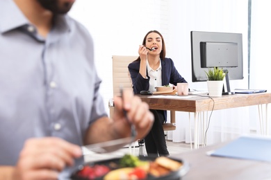 Photo of Office employee having lunch at workplace. Food delivery