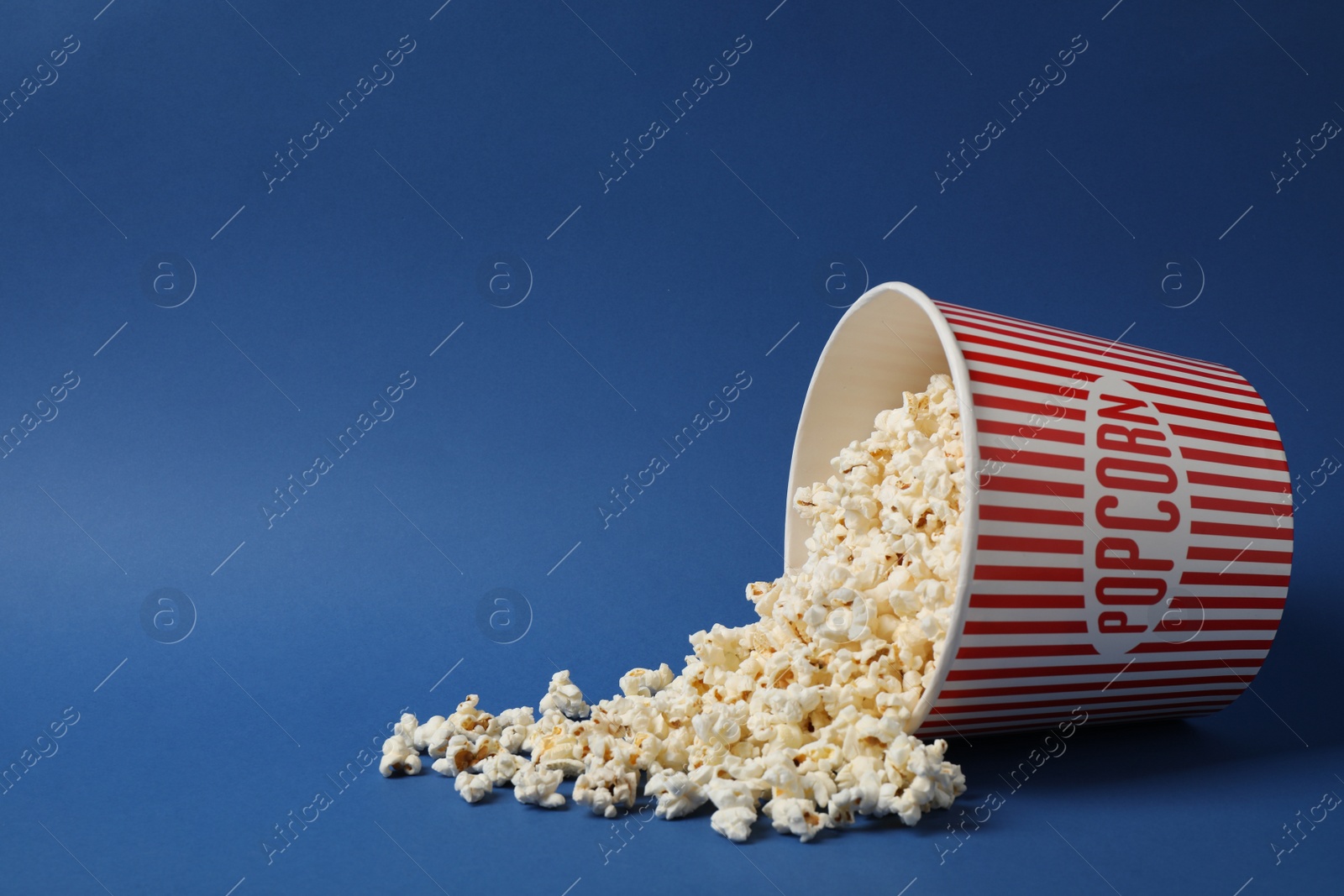 Photo of Delicious popcorn on blue background. Space for text