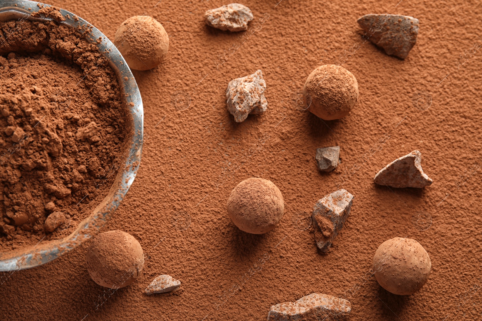 Photo of Flat lay composition with tasty raw chocolate truffles on cocoa powder
