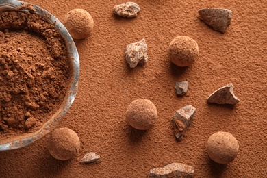 Flat lay composition with tasty raw chocolate truffles on cocoa powder