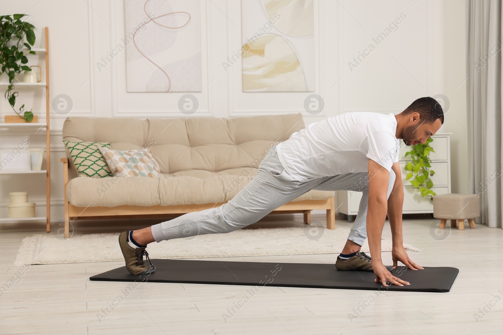 Photo of Man doing morning exercise on fitness mat at home