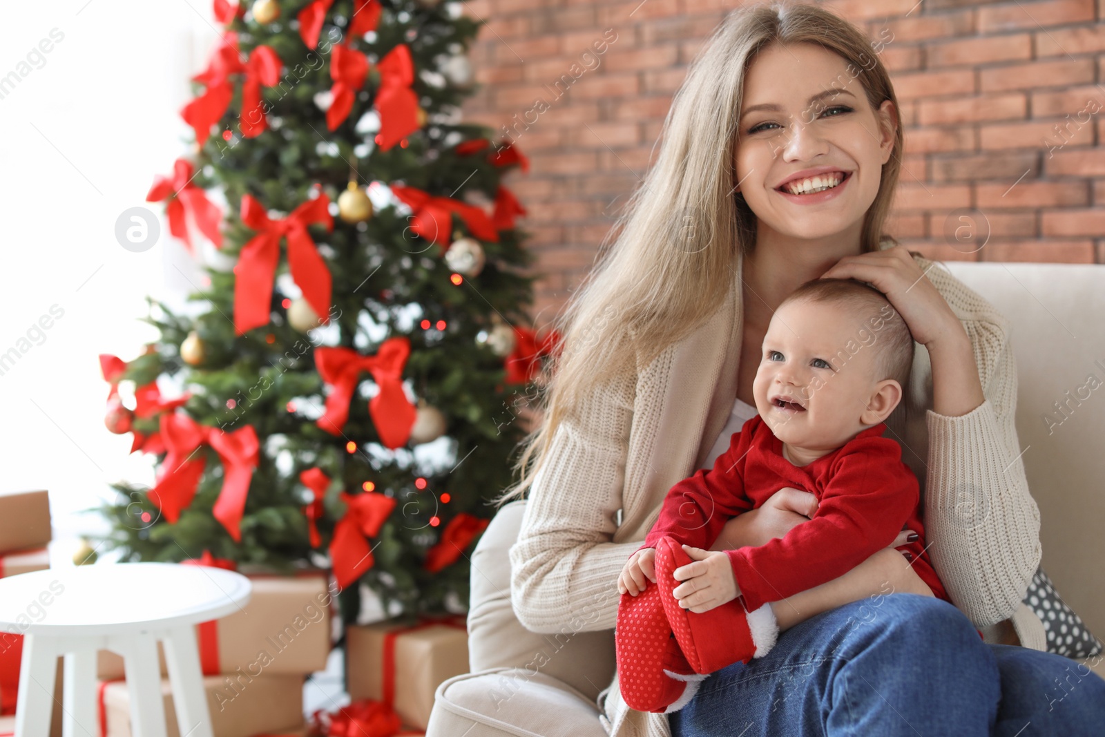 Photo of Young woman with baby celebrating Christmas at home