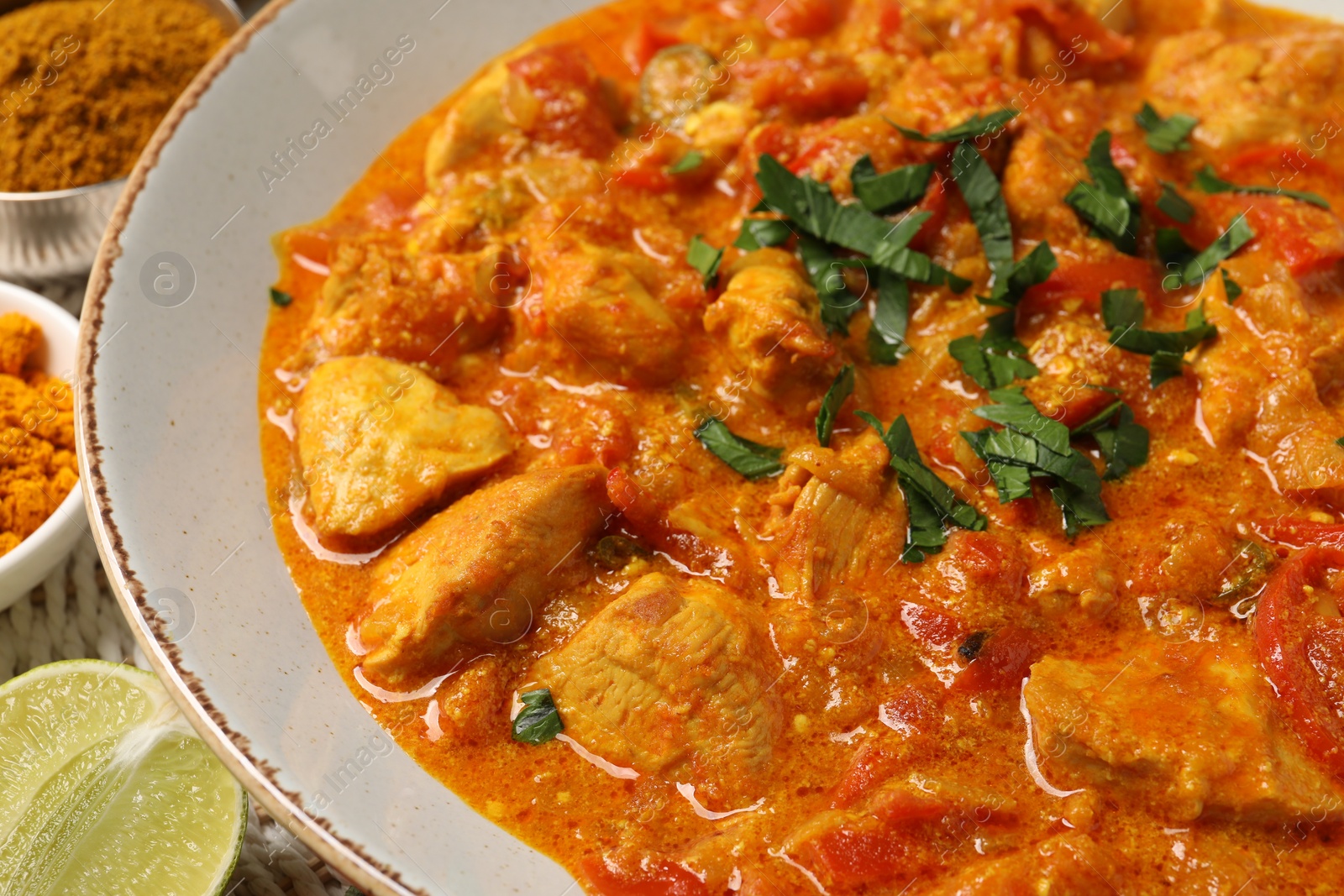 Photo of Delicious chicken curry with parsley on table, closeup