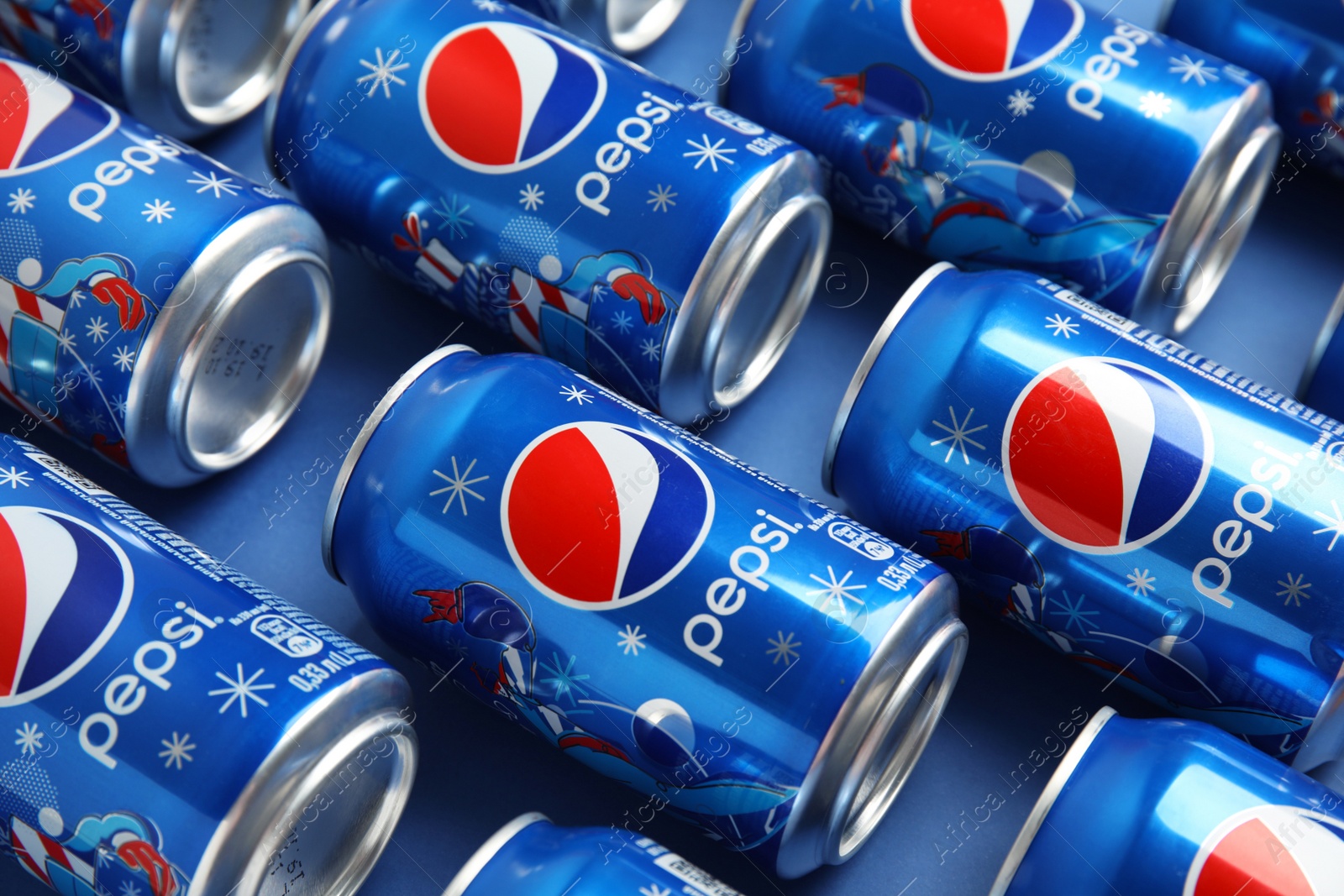 Photo of MYKOLAIV, UKRAINE - FEBRUARY 08, 2021: Cans of Pepsi on blue background, closeup