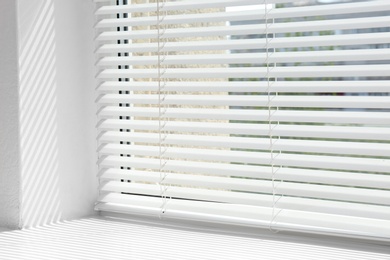 Photo of Window with open modern horizontal blinds indoors, closeup