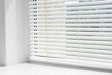 Window with open modern horizontal blinds indoors, closeup