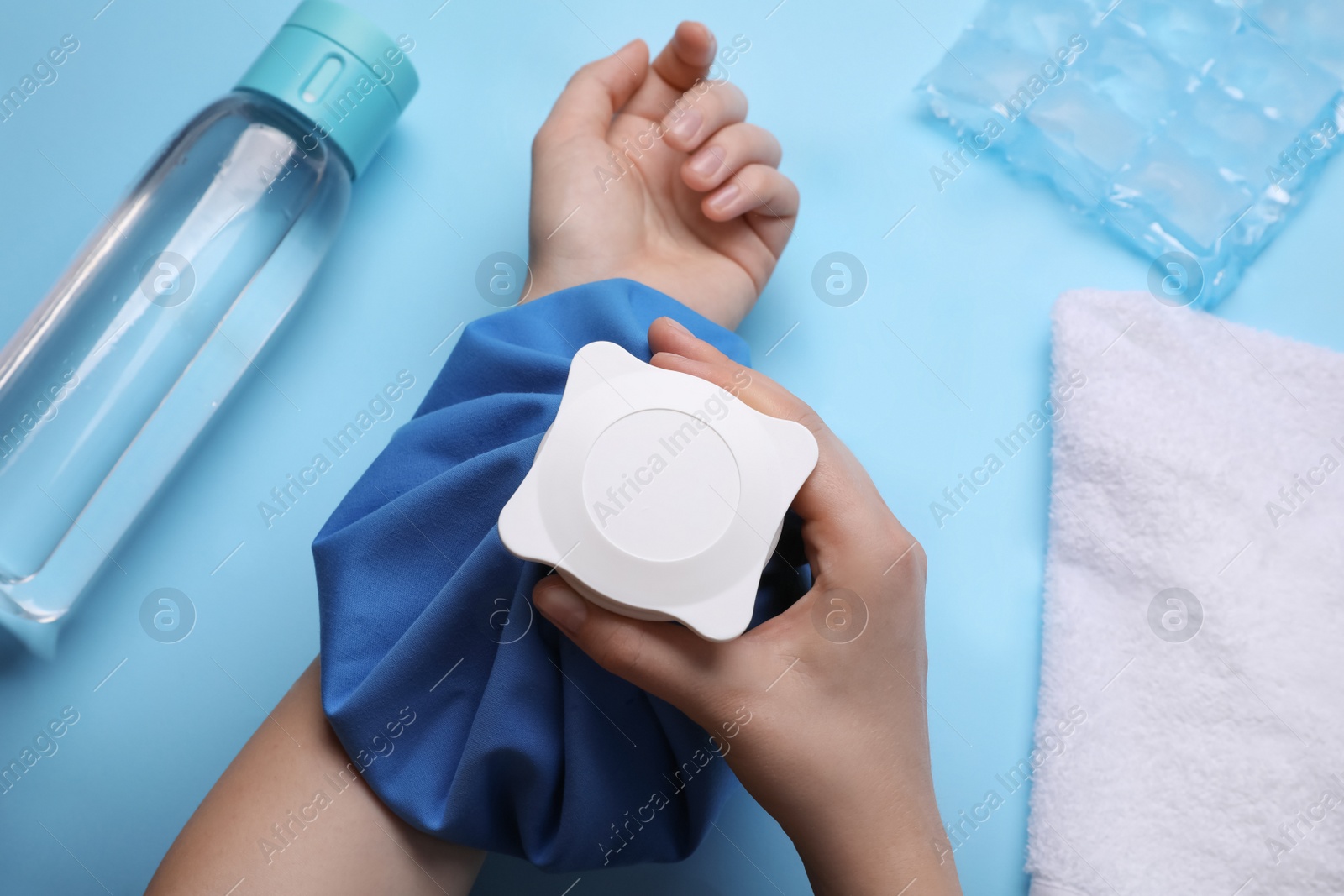 Photo of Woman with cold compress on light blue background, top view. Heat stroke treatment