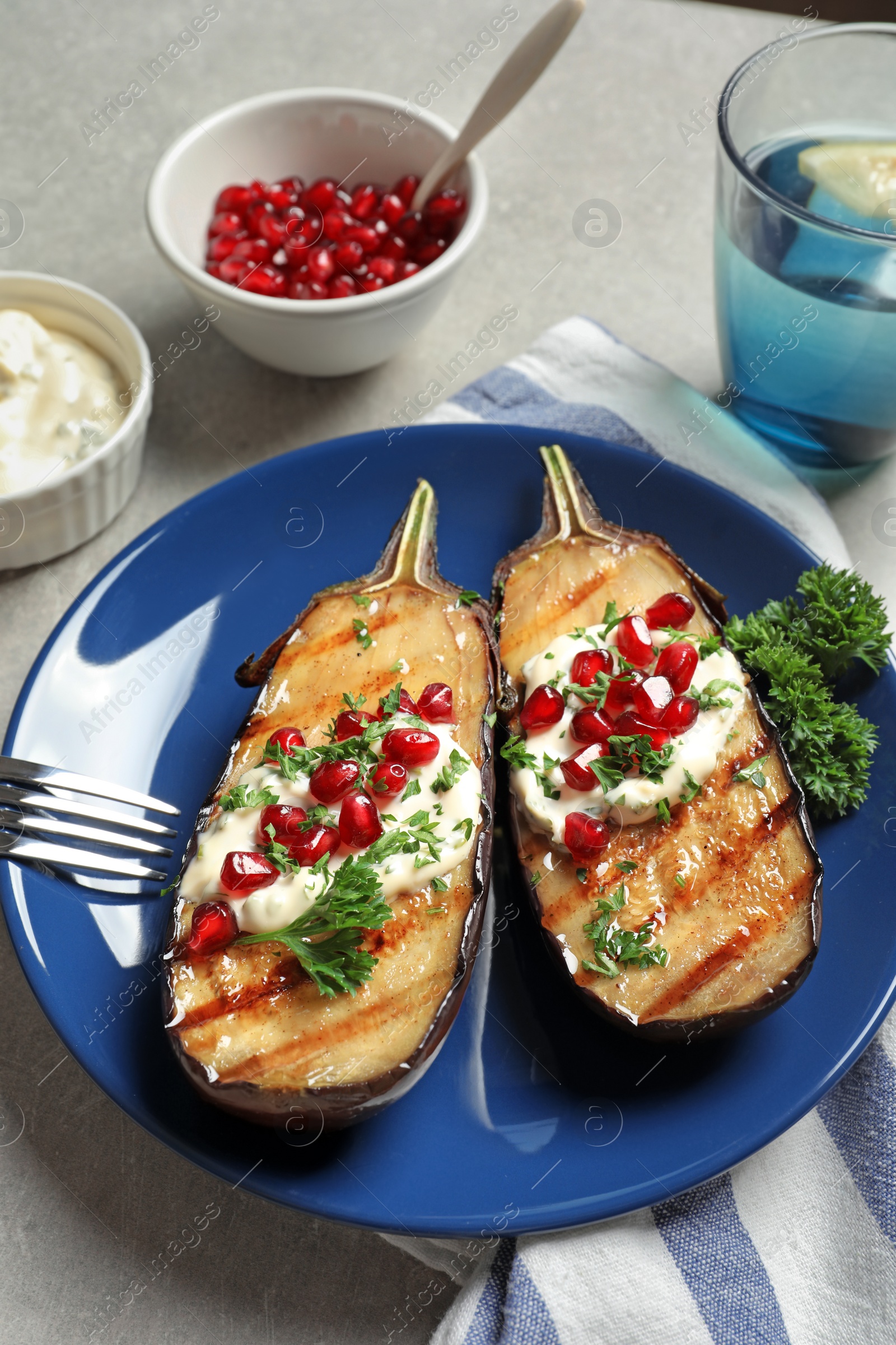 Photo of Plate with tasty fried eggplants on gray table