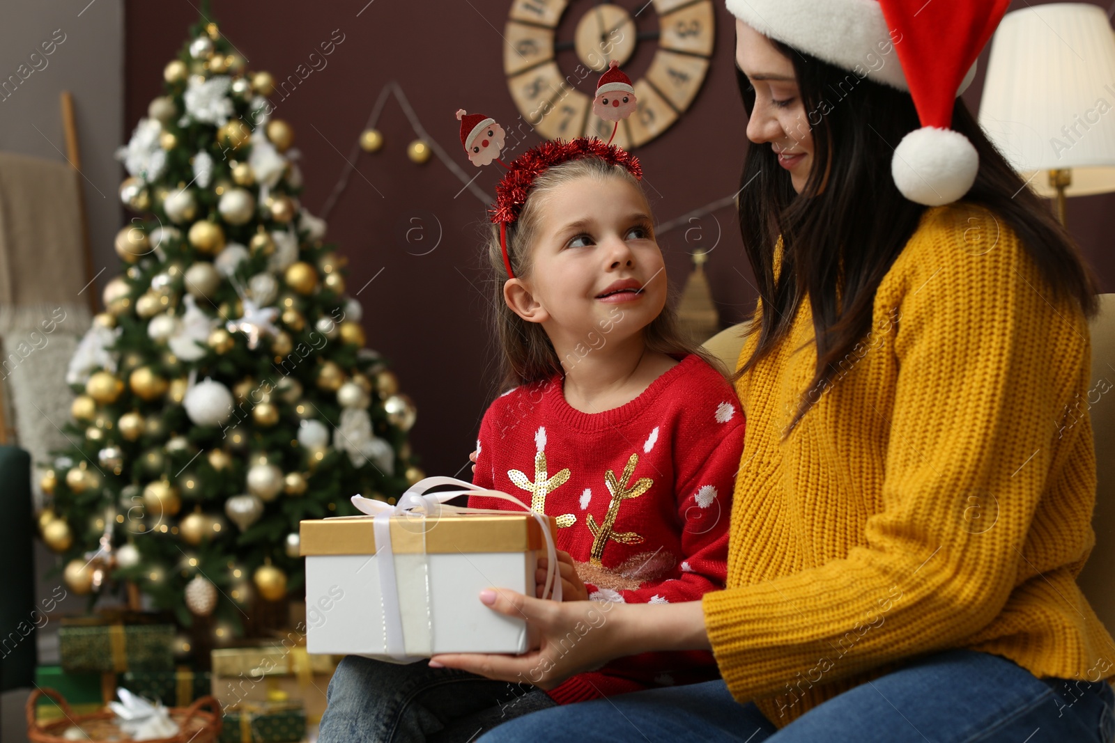 Photo of Mother and daughter with gift box at home. Christmas celebration
