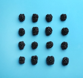 Fresh ripe blackberries on blue background, flat lay