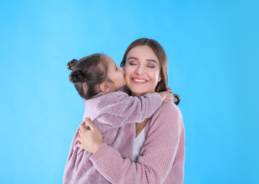Photo of Young mother and little daughter on blue background