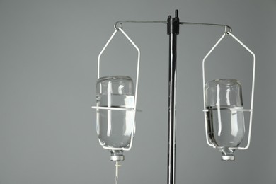 Photo of IV infusion set on pole against grey background