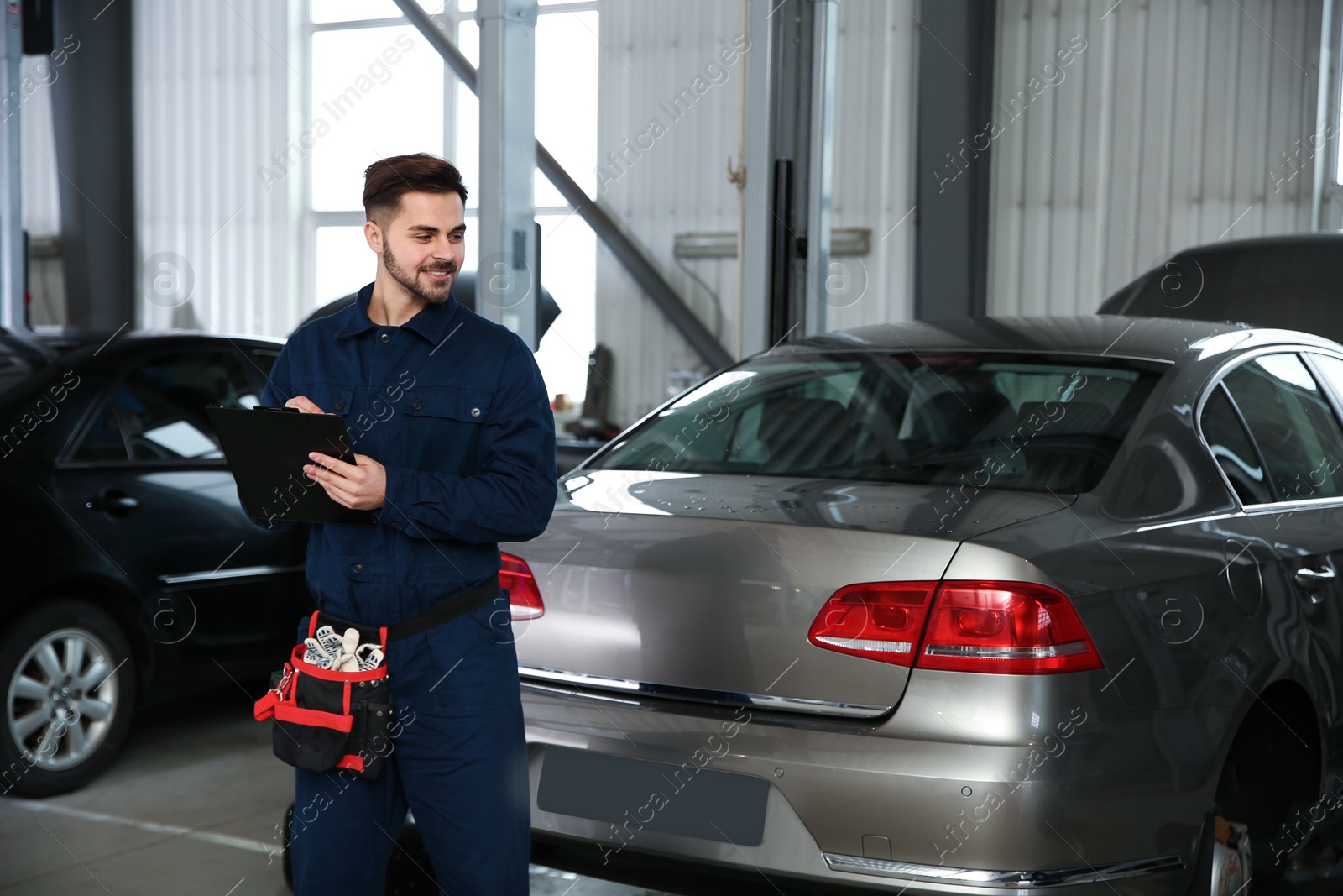 Photo of Portrait of technician with clipboard at automobile repair shop