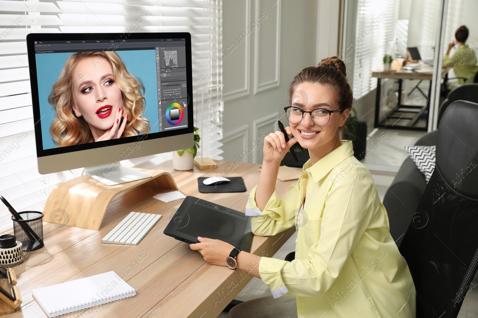 Photo of Professional retoucher working on graphic tablet at desk in office