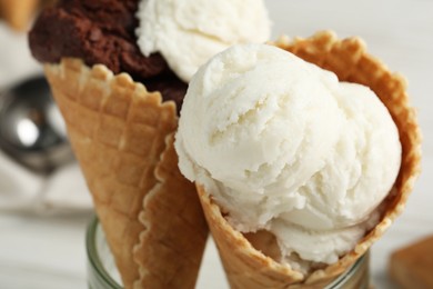 Photo of Ice cream scoops in wafer cones on table, closeup