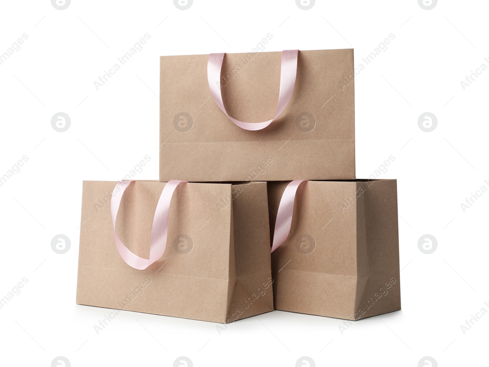 Photo of Paper shopping bags with ribbon handles on white background. Mockup for design