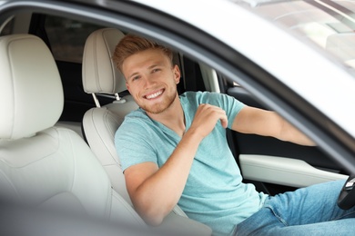 Photo of Happy young man driving his luxury car