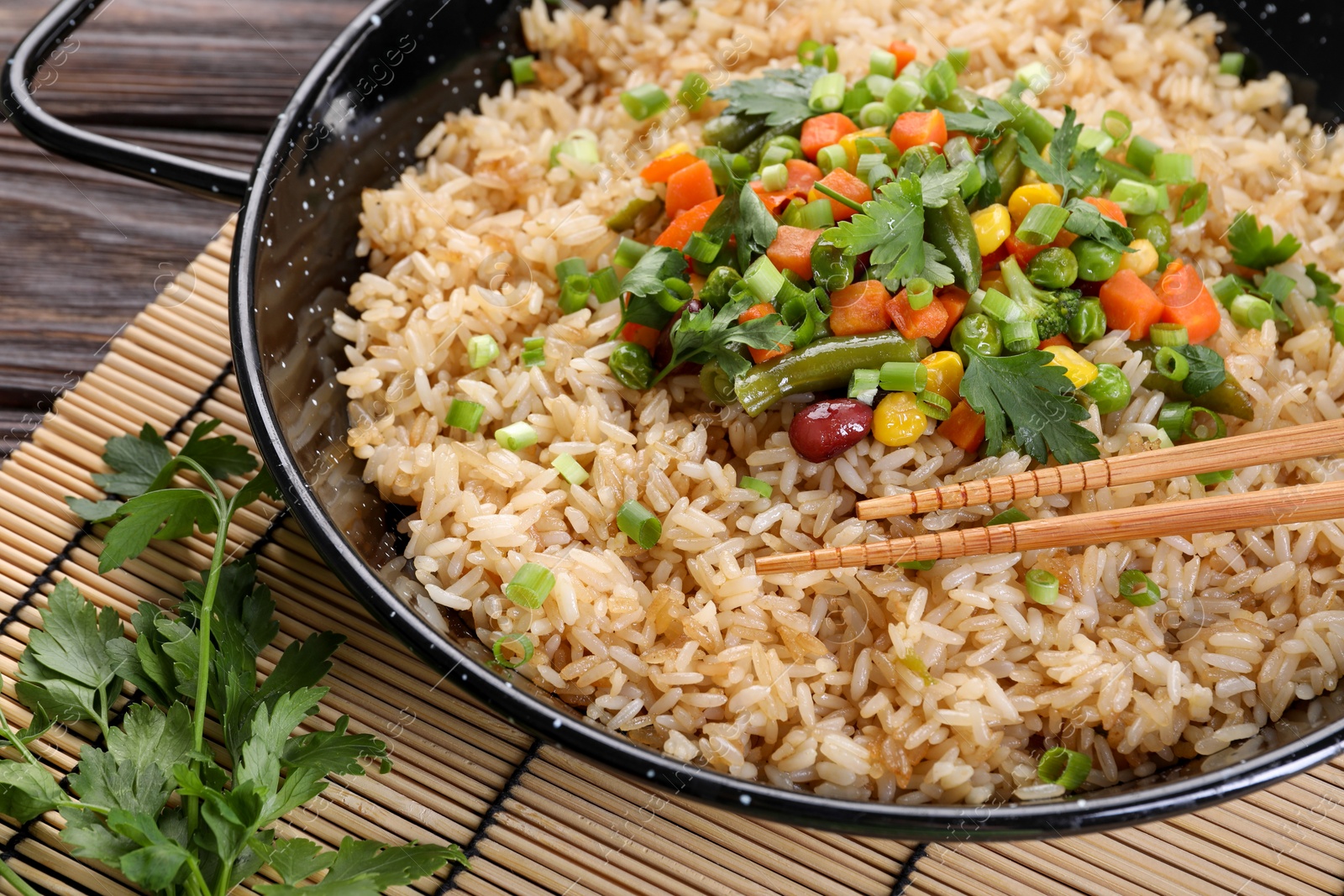 Photo of Tasty fried rice with vegetables served on wooden table, closeup
