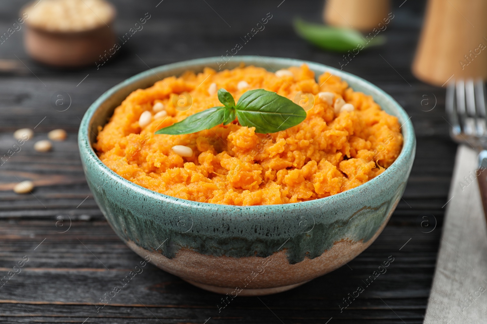 Photo of Bowl with mashed sweet potatoes on wooden table