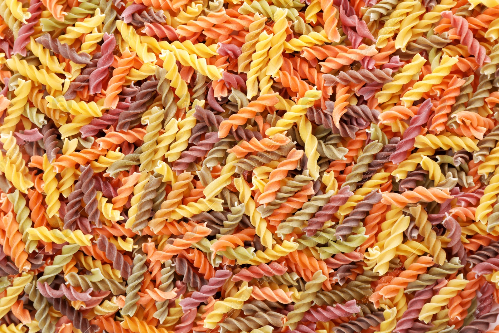 Photo of Uncooked fusilli pasta as background, closeup