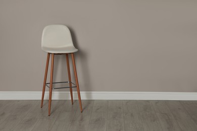 Photo of Stylish bar stool near light grey wall indoors. Space for text