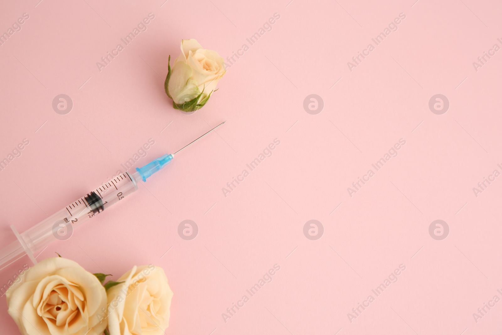 Medical syringe and rose flowers on pink background, flat lay. Space for text Photo of Medical syringe and rose flowers on pink background, flat lay. Space for text
