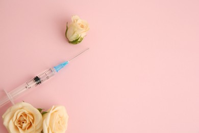 Photo of Medical syringe and rose flowers on pink background, flat lay. Space for text