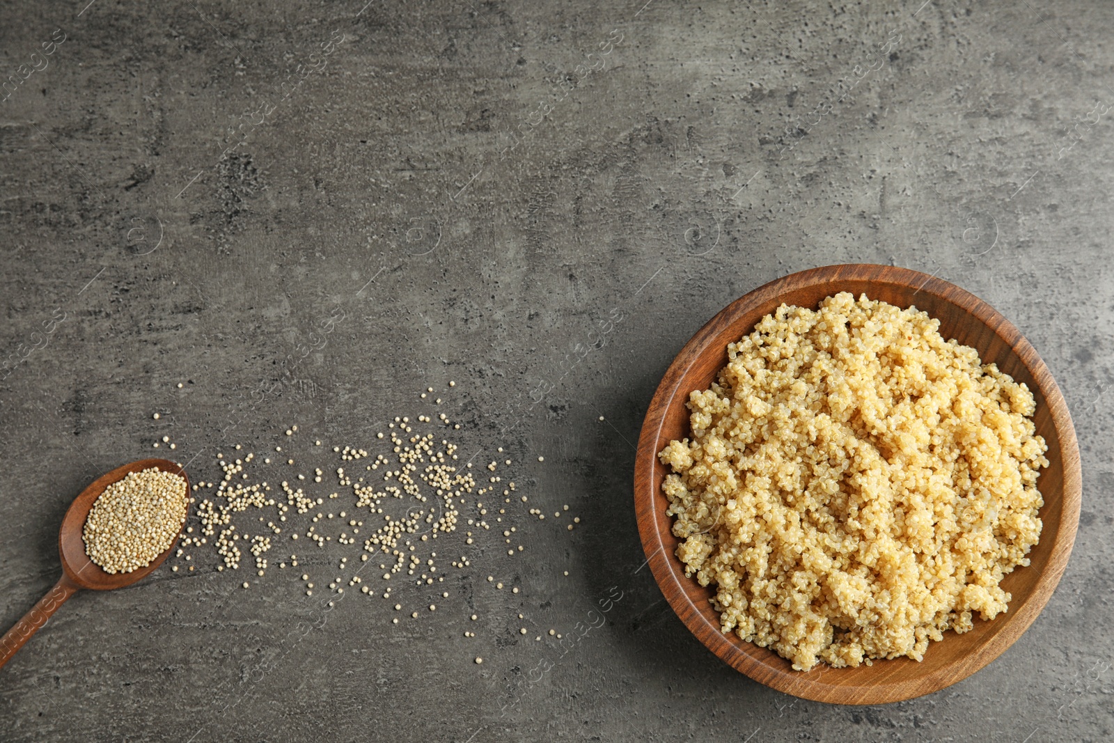 Photo of Cooked delicious quinoa in wooden bowl on table, top view. Space for text