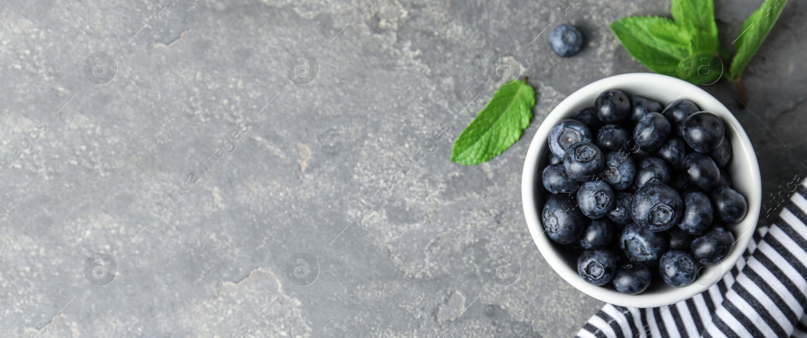 Image of Tasty fresh blueberries on light grey table, flat lay with space for text. Banner design