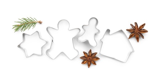 Different cookie cutters, fir branch and anise stars on white background, top view