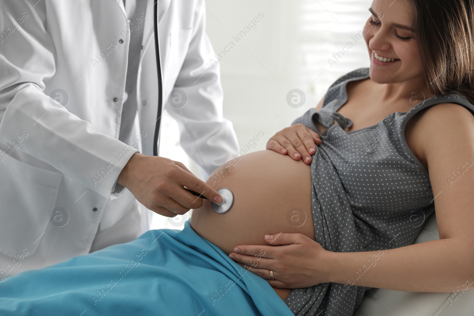 Photo of Doctor examining woman before giving child birth in maternity hospital, closeup