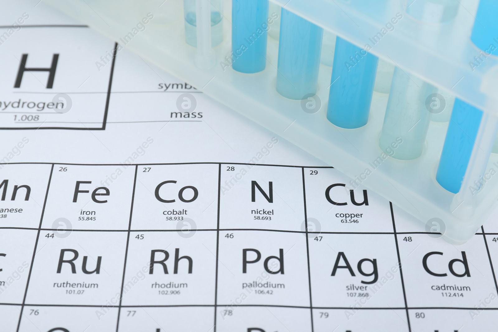 Photo of Test tubes in rack on periodic table of chemical elements, closeup