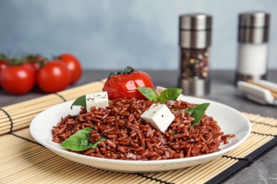 Photo of Plate with delicious cooked brown rice on table