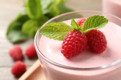 Photo of Glass of delicious raspberry mousse with mint, closeup